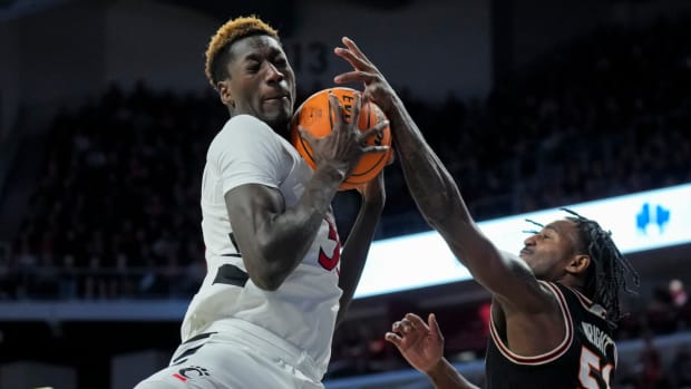 Feb 21, 2024; Cincinnati, Ohio, USA; Cincinnati Bearcats forward Aziz Bandaogo (55) rebounds the ball against Oklahoma State Cowboys guard John-Michael Wright (51) in the first half at Fifth Third Arena. Mandatory Credit: Aaron Doster-USA TODAY Sports